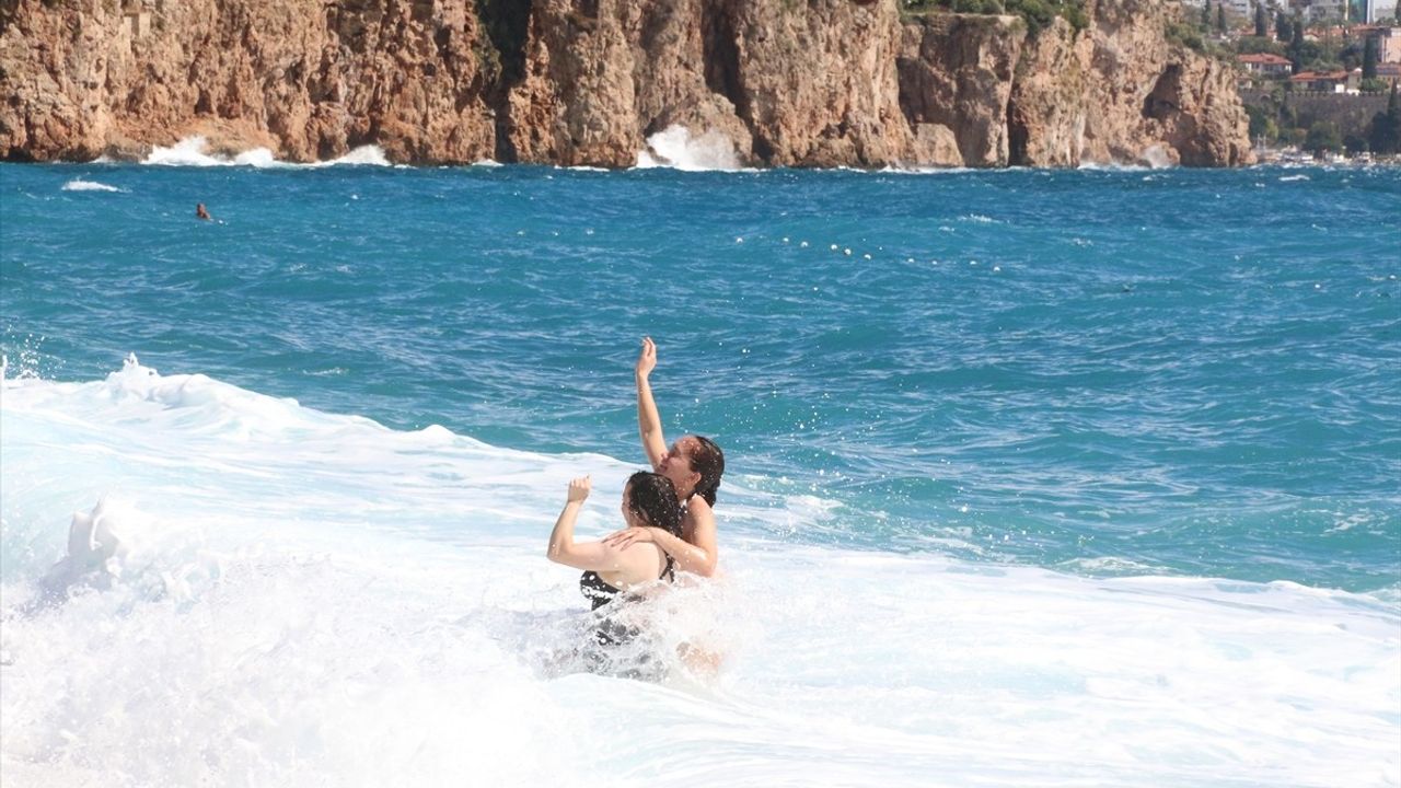 Antalya'da dalgalı denize rağmen bazı yabancı turistler Konyaaltı Sahili'nde yüzdü
