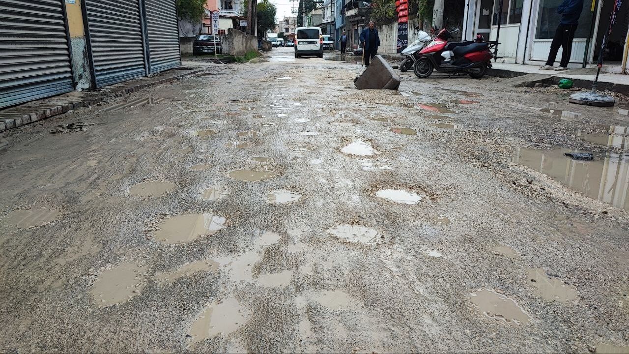Adana'da Defne Caddesi'nde altyapı çalışması sonrası yol çökmesi; esnaf kanepe koluyla önlem aldı