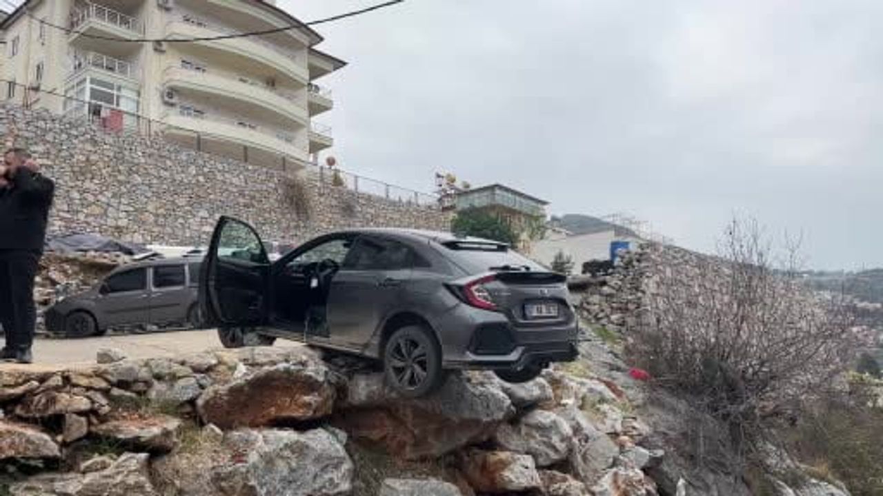 Alanya'da geri manevra yapan SUV yol kenarındaki şarampolde asılı kaldı