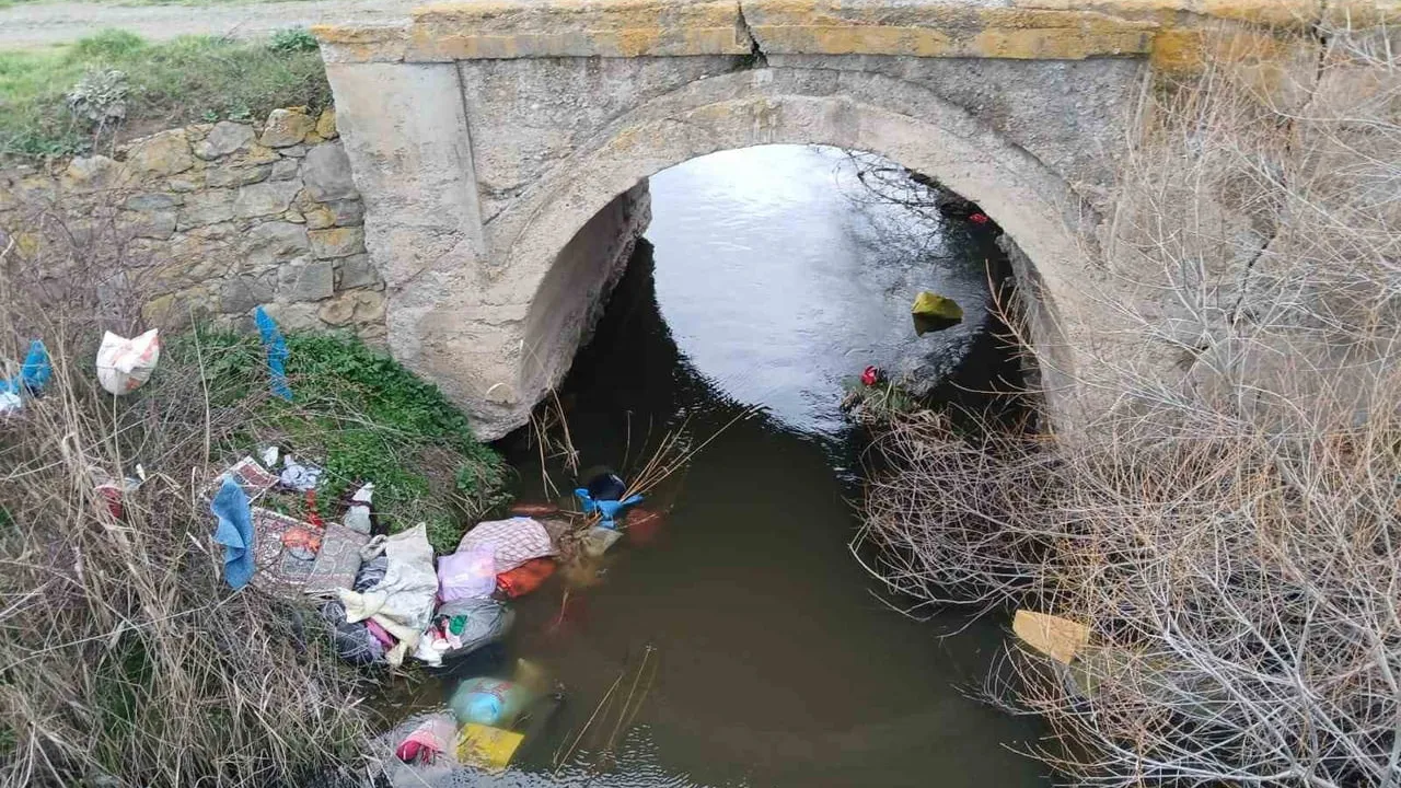 Tavşanlı'da köprü altına bırakılan çöpler çevre kirliliğini artırıyor