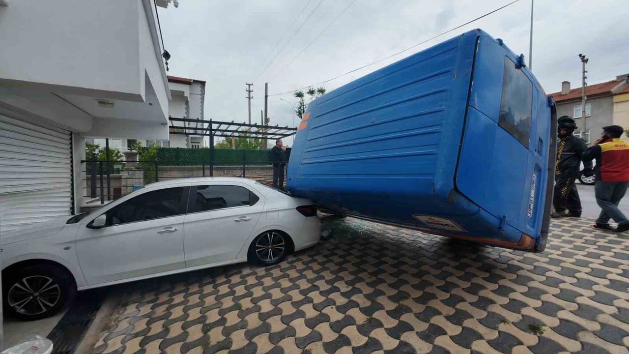 Karaman'da kargo minibüsü park halindeki otomobilin üzerine devrildi; motokurye müdahalesi kamerada