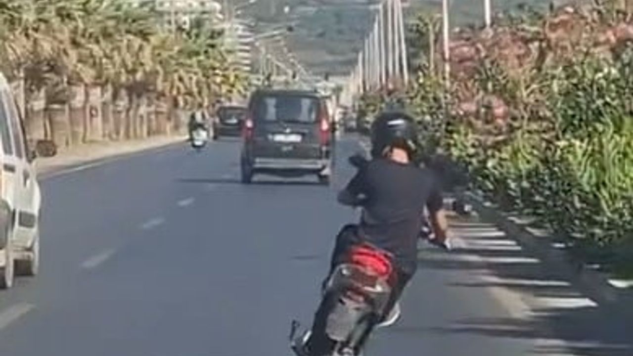 Alanya'da elektrikli motosiklet üzerinde ayakta giden sürücünün tehlikeli yolculuğu kamerada