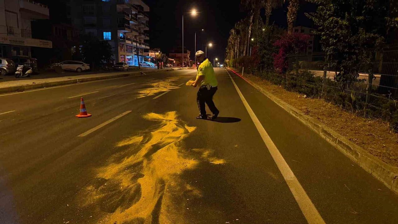 Antalya'da trafik polisi kaza sonrası yola dökülen yağı kürekle tozlayarak temizledi