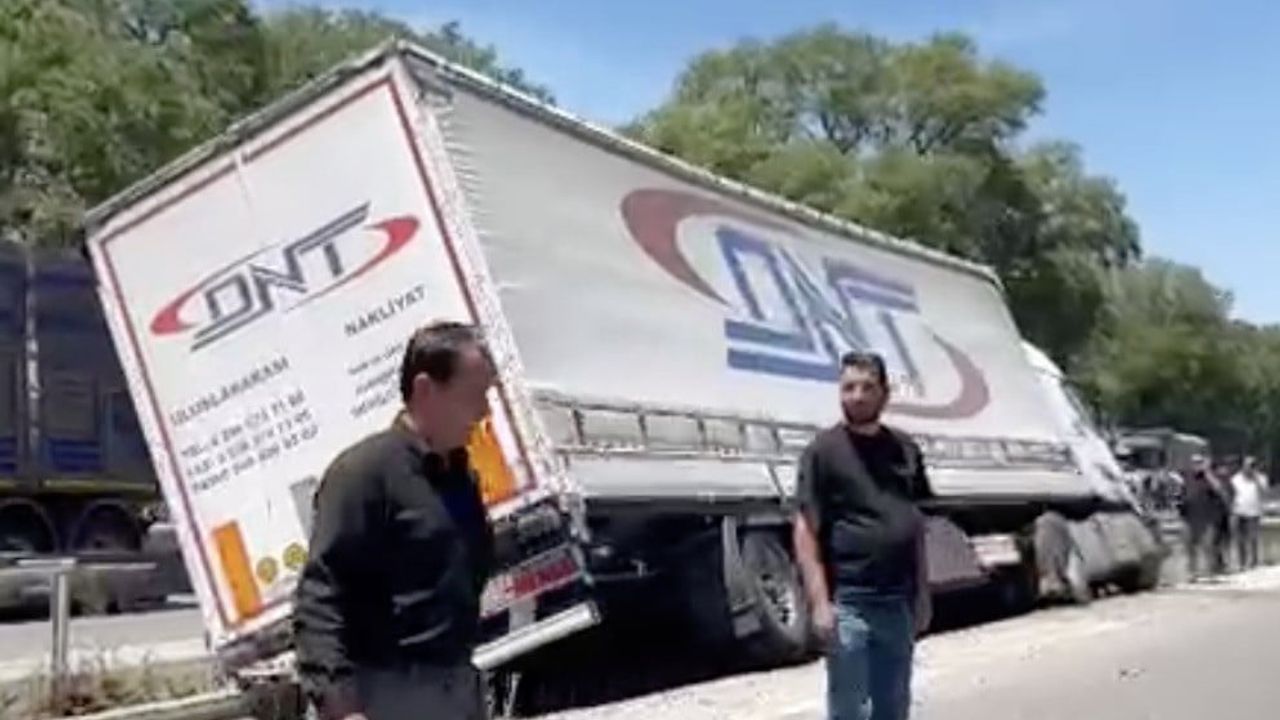 Karacabey’de ön lastiği patlayan tır refüje girip devrildi