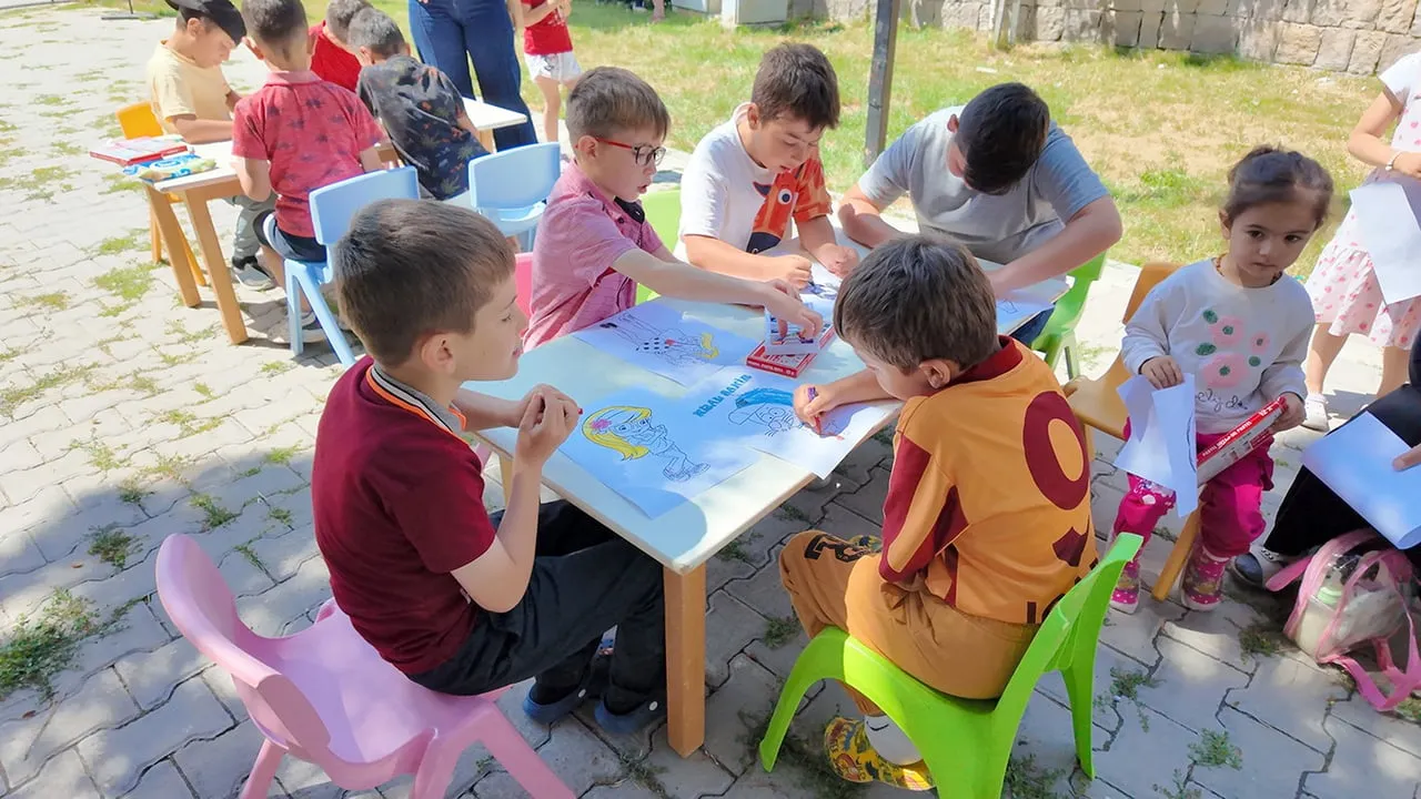 Kütüphane geziyor, çocuklar hem okuyor hem eğleniyor