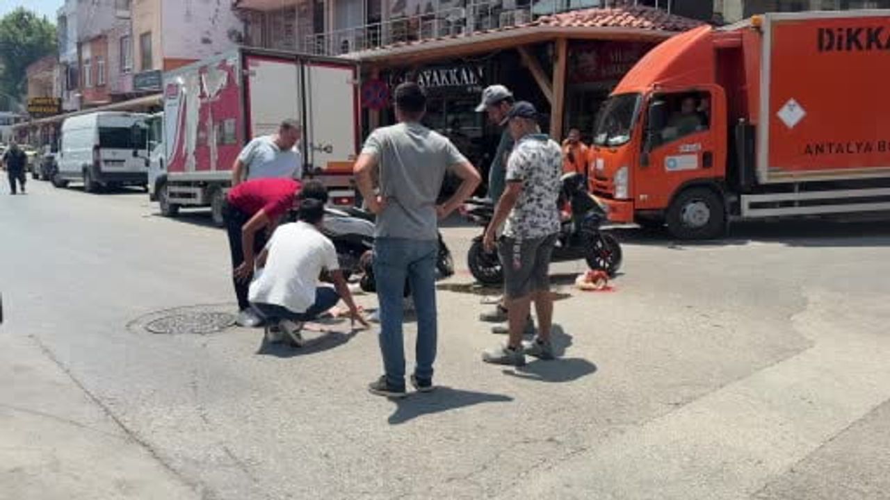 Serik'te motosiklet kazasında yaralanan genç kadına esnaftan şemsiyeli destek
