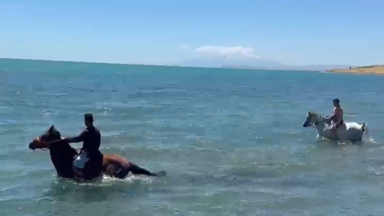 Sıcaktan bunalan gençler atlarla Van Gölü’nde serinledi
