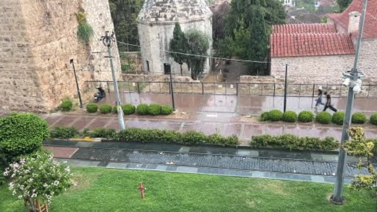 Temmuzda beklenmedik kısa yağmur Antalya'da tatilcileri şemsiyeye mecbur bıraktı