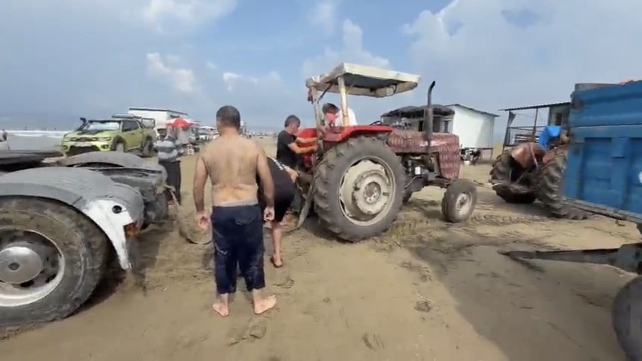 Plajın kumuna gömülen tır iki traktörün çekişiyle kurtarıldı