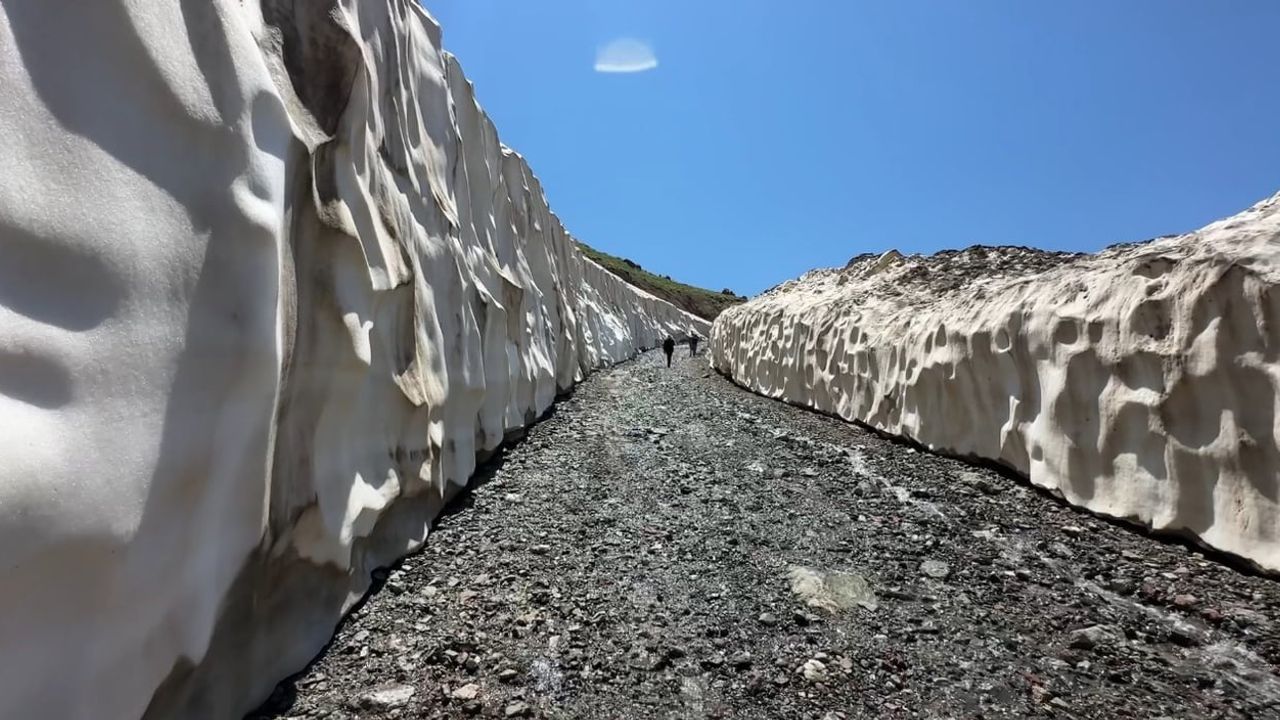 Yüksekova'da ağustosta yaz güneşi ile metrelerce kar bir arada