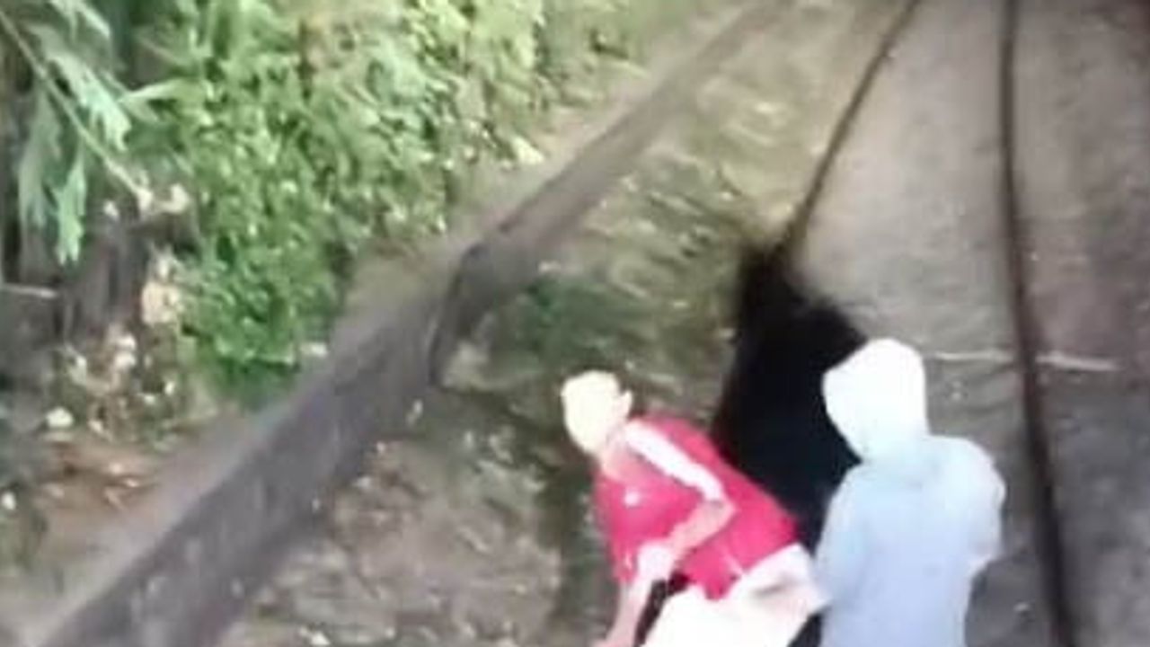 Alsancak'ta raylara çıkan iki kişi trene alınmayınca taş attı