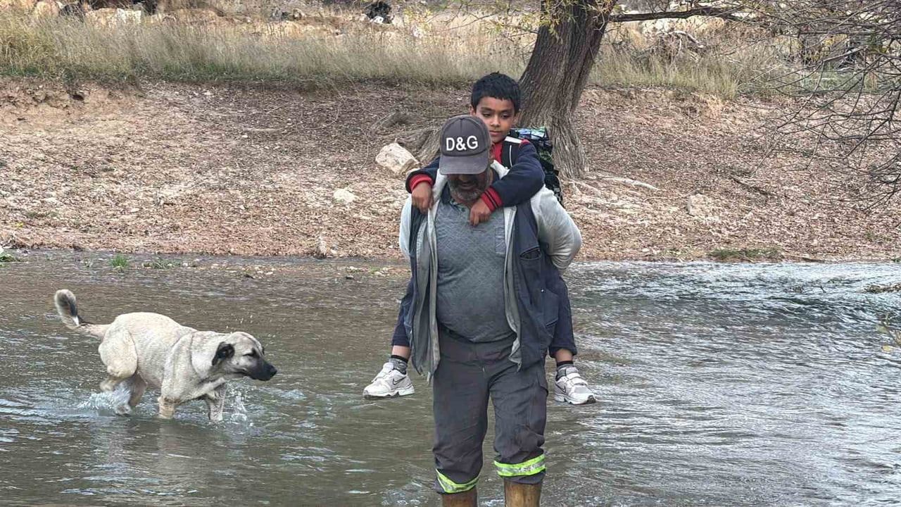 Irmağın ortasında eğitim mücadelesi: köprü yıkılınca evladını sırtında geçiriyor