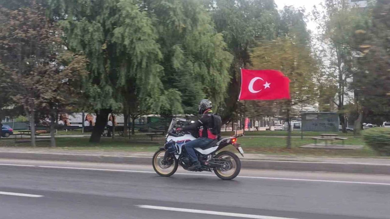 motosikletine astığı bayraklarla çevre yolunda dikkat çeken sürücü