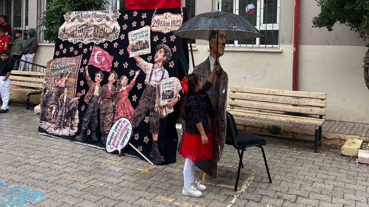 Yağmura aldırmadan Atatürk maketini koruyan küçük kızın davranışı yürek ısıttı