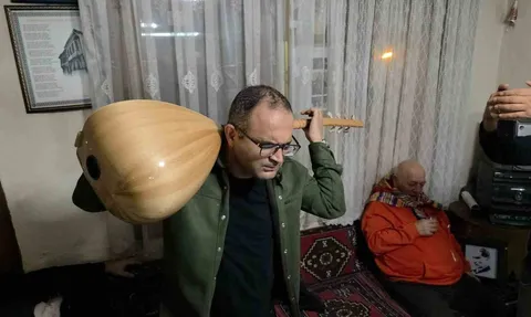 Kütahya'da görme engelli müzisyen İsmail Barış sazı ensesinde çalarak performans sergiliyor