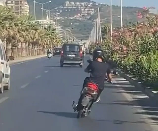 Alanya'da elektrikli motosiklet üzerinde ayakta giden sürücünün tehlikeli yolculuğu kamerada