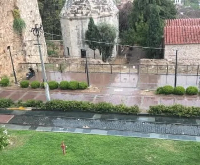 Temmuzda beklenmedik kısa yağmur Antalya'da tatilcileri şemsiyeye mecbur bıraktı