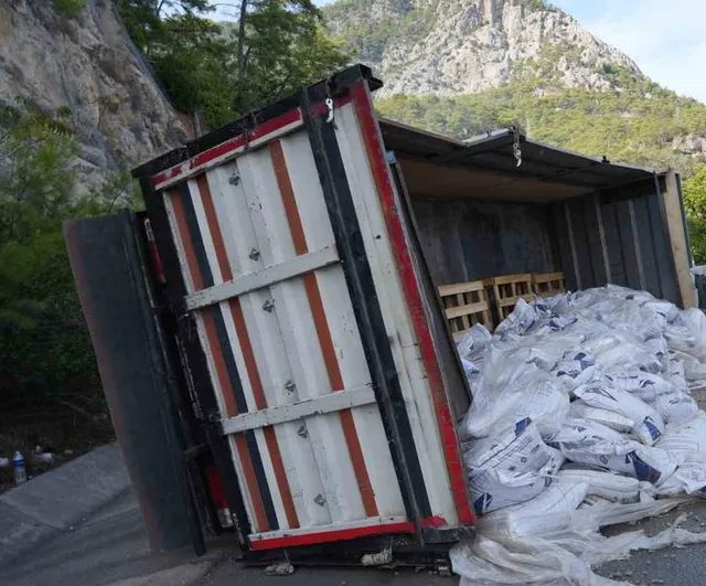 Pelet yüklü kamyon virajı alamayıp bariyerlere çarptı, kasası devrildi