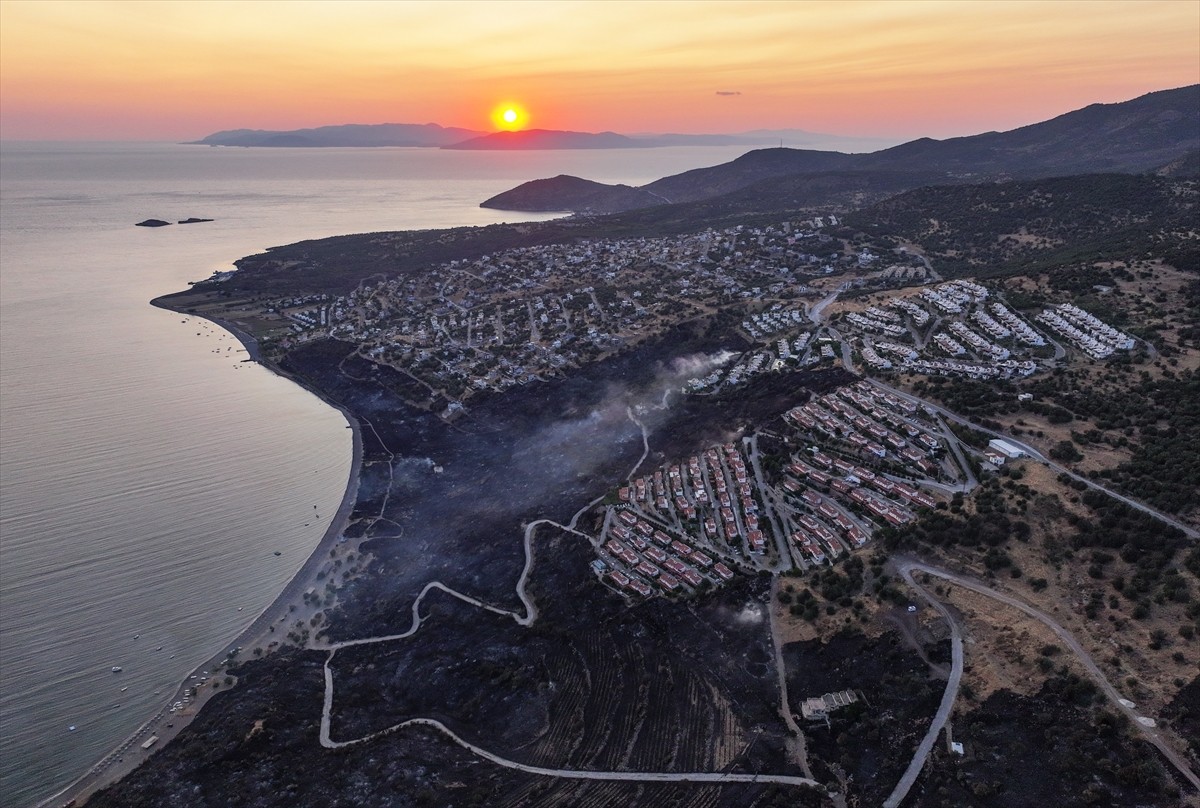 İzmir'in Dikili ilçesinde ormanlık alanda başlayan ve yerleşim yerlerine yaklaşan yangına havadan...