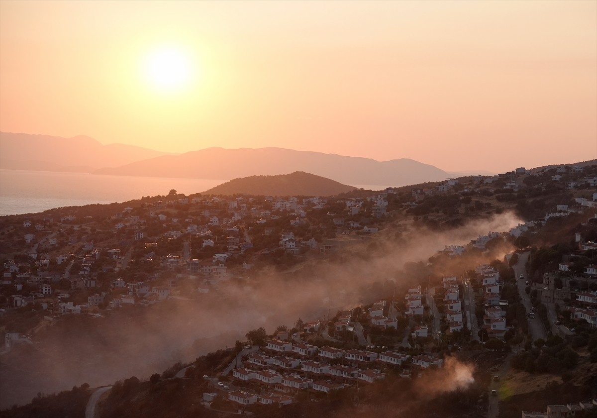 İzmir'in Dikili ilçesinde ormanlık alanda başlayan ve yerleşim yerlerine yaklaşan yangına havadan...