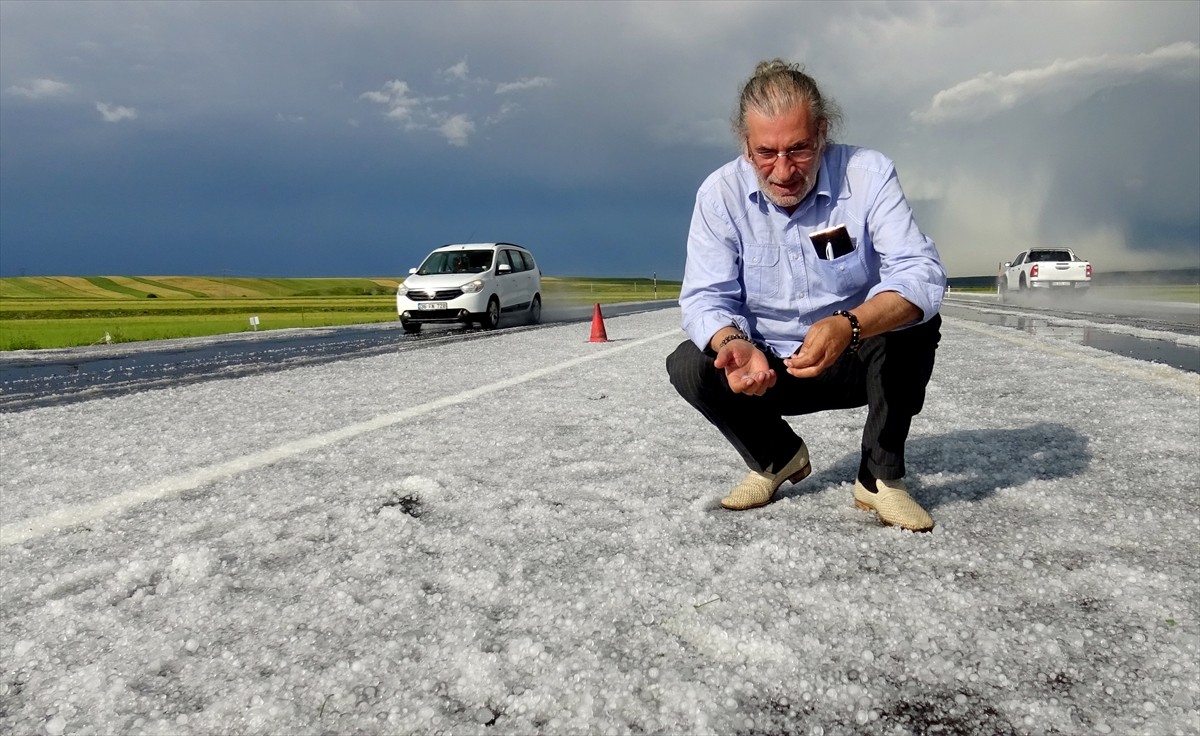 Kars'ta sağanak sonrası yağan dolu, kara yolunu ve evlerin bahçelerini beyaz örtüyle kapladı.