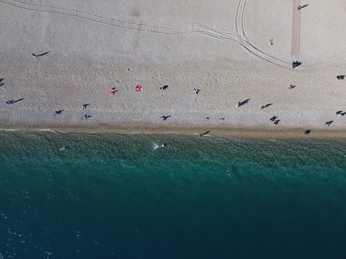 Antalya'da güneşli havayı değerlendirmek isteyen turistler ve kent sakinleri, sahillerde...