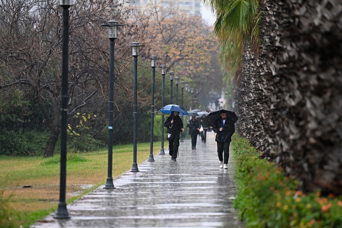 Antalya'da sağanak hayatı olumsuz etkiledi. Bazı vatandaşlar, şemsiyeyle yağmurdan korunmaya...