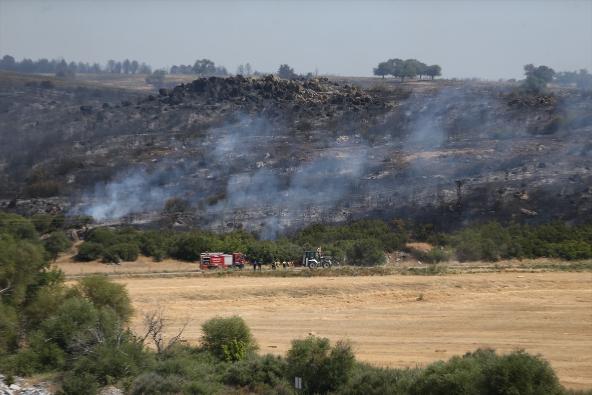 Çanakkale'nin Ezine ilçesinde tarım arazisinde başlayan ve ormanlık alana sıçrayan yangına havadan...