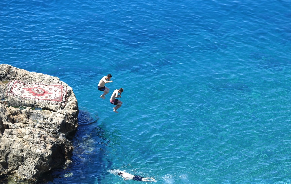 Antalya'da sıcak hava ve nemden bunalan yerli ve yabancı turistler, sahillerde ve gölgelik...