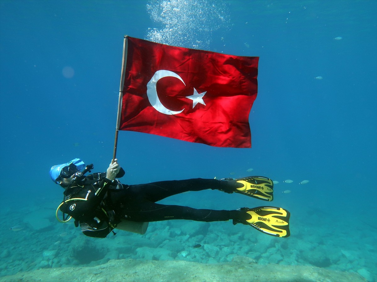 Muğla'nın Fethiye ilçesinde bir dalış okulunun dalgıçları, 30 Ağustos Zafer Bayramı nedeniyle su...