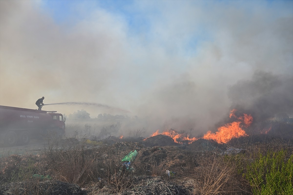 Antalya'nın Aksu ilçesinde çöp ve molozların bulunduğu alanda çıkan yangın ekiplerce...