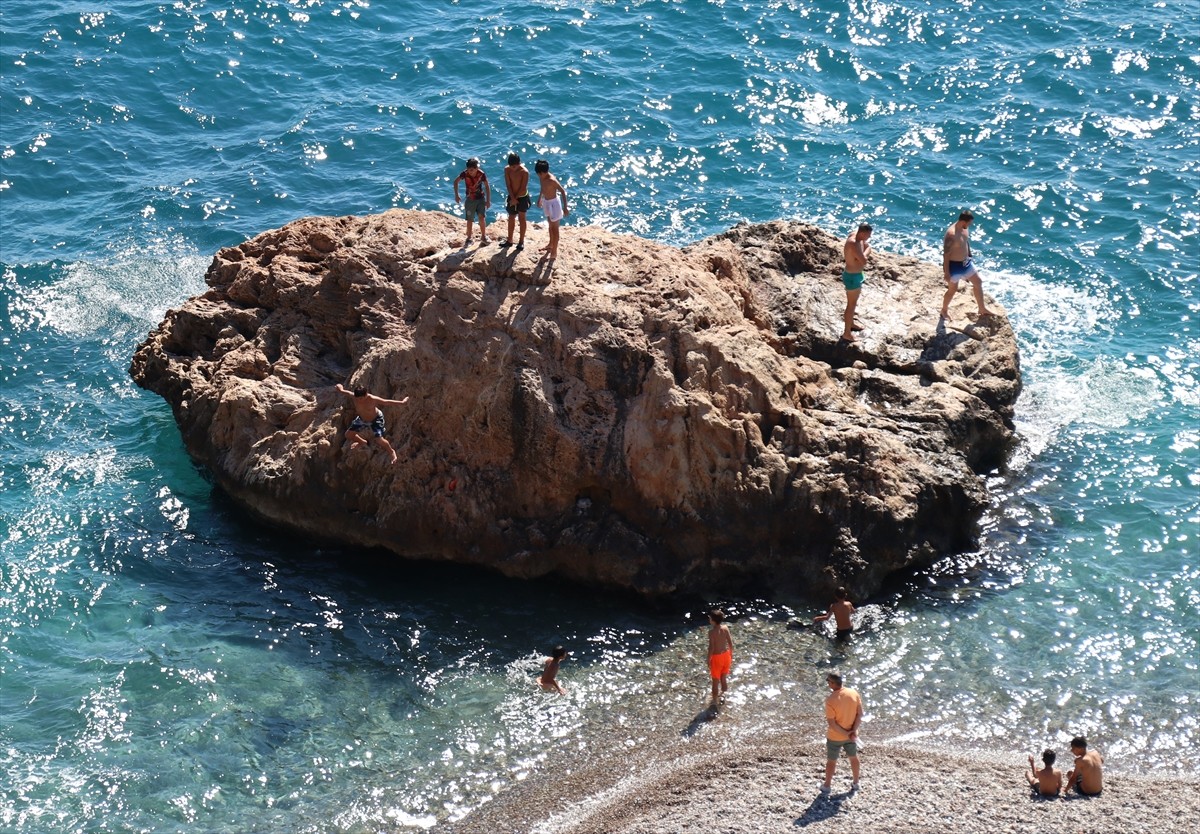 Hava sıcaklığının 28 derece olarak kaydedildiği Antalya'da, denize giren ve güneşlenenler...