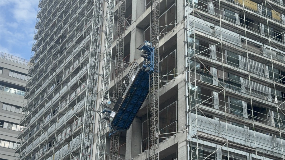 İstanbul Bahçelievler'de, bir inşaatın dış cephesinde asılı kalan asansörde bulunan işçiler...