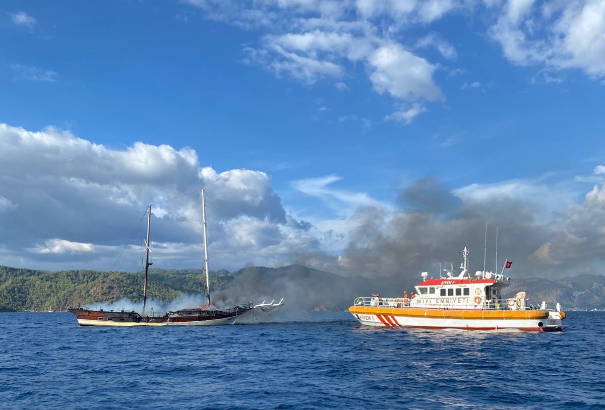 Muğla'nın Fethiye ilçesinde yangın çıkan tekne, söndürme çalışmaları sırasında suya...