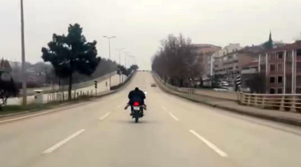 KARABÜK’TE TRAFİKTE MOTOSİKLETİN ÜZERİNE YATARAK TEHLİKELİ YOLCULUK YAPAN SÜRÜCÜ KAMERAYA...