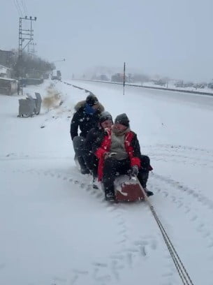 MALATYA'NIN AKÇADAĞ İLÇESİNDE TRAKTÖRÜN ARKASINA BAĞLANAN KÜTÜK ÜZERİNDE KARDA 'SÖRF' YAPAN...