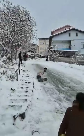 TOKAT’IN NİKSAR İLÇESİNDE KARLI VE KAYGAN YOLDA POŞETLERLE KAYAN GENÇLER, HIZLARINI ALAMAYARAK...