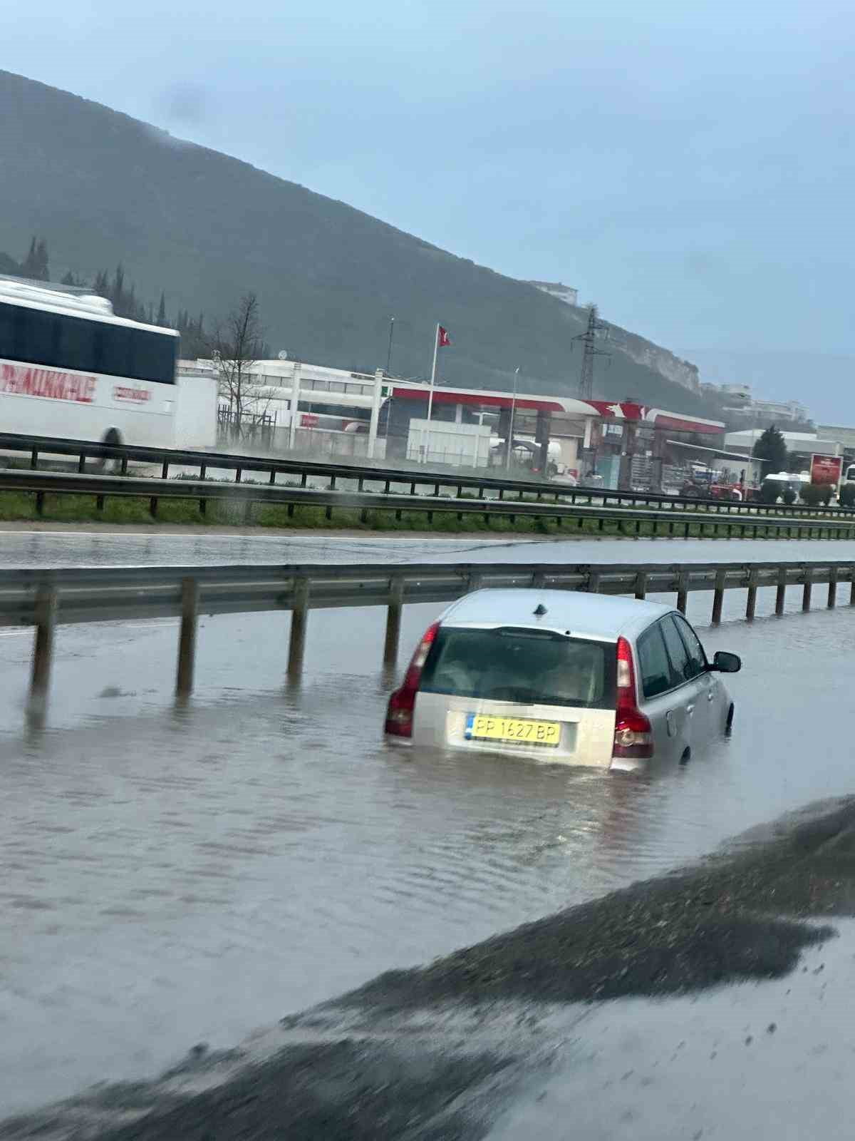 BURSA'DA SAĞANAK NEDENİYLE GÖLE DÖNEN GEMLİK-ORHANGAZİ KARA YOLUNDA MAHSUR KALAN ARAÇ ÇEKİCİYLE...