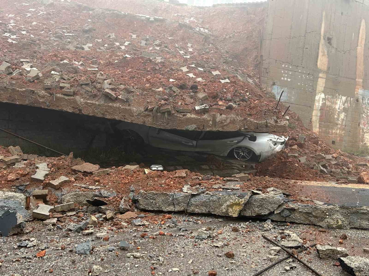 MALTEPE'DE BİR OKULUN İSTİNAT DUVARININ ÇÖKMESİYLE PARK HALİNDEKİ BİR ARAÇ ADETA KAĞIT GİBİ...