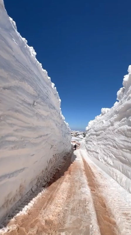 YOLUN İKİ YANINDA DUVAR GİBİ YÜKSELEN KAR BİRİKİNTİLERİ ARASINDA KALAN YOL DİKKAT ÇEKTİ