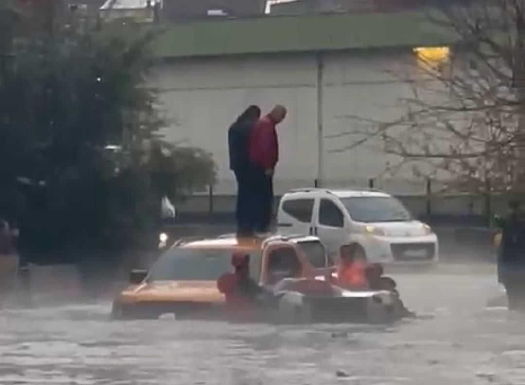 ADANA'DA DOLU VE SAĞANAK NEDENİYLE GÖLE DÖNEN YOLDA OTOMOBİLİN ÜZERİNDE ÇIKAN 2 KİŞİ İTFAİYE...
