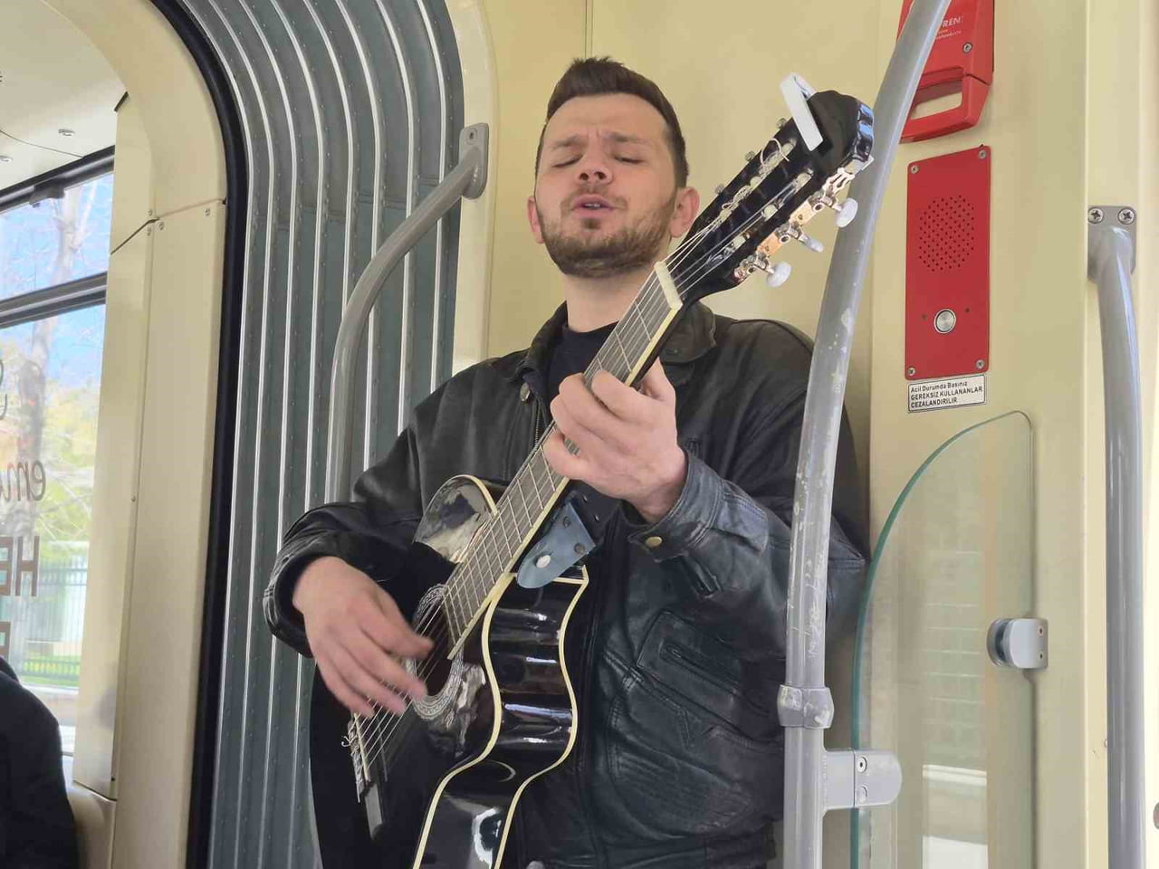 ESKİŞEHİR'DE BİNDİĞİ TRAMVAYDA GİTARIYLA KÜÇÜK BİR KONSER VEREN GENÇ MÜZİSYEN, YOLCULARA KEYİFLİ...