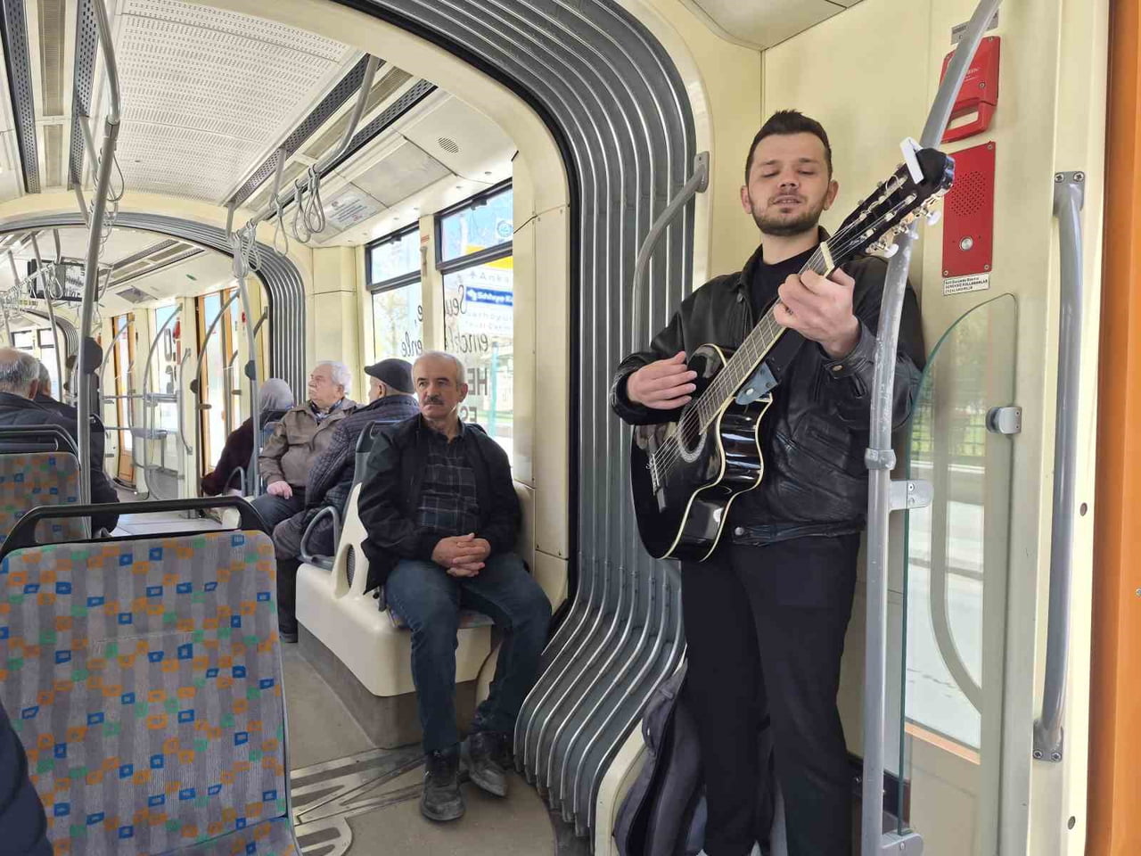 ESKİŞEHİR'DE BİNDİĞİ TRAMVAYDA GİTARIYLA KÜÇÜK BİR KONSER VEREN GENÇ MÜZİSYEN, YOLCULARA KEYİFLİ...