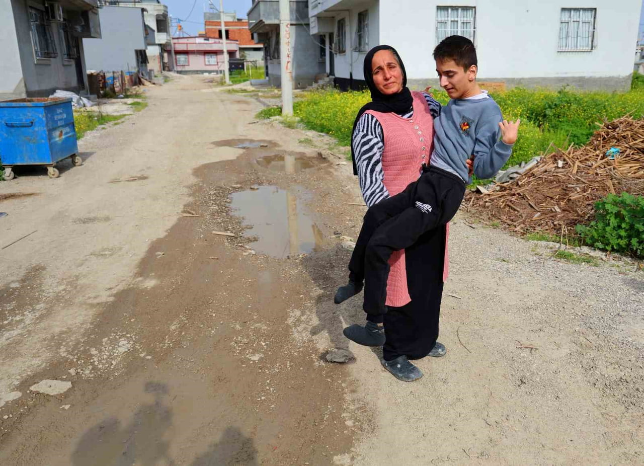 EYLEM SIRASINDA CEMİLE ATAY İSİMLİ KADIN, ENGELLİ EVLADINI KUCAĞINA ALIP GELEREK, "OKUL SERVİSİ...