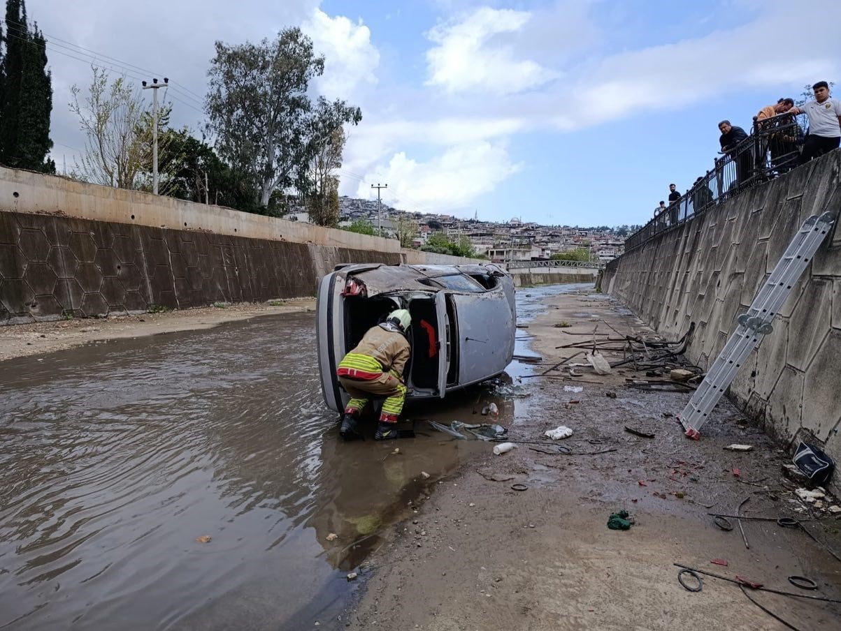 HATAY’A SÜRÜCÜSÜNÜN DİREKSİYON HAKİMİYETİNİ KAYBETMESİYLE KANALA DÜŞEREK YAN YATAN OTOMOBİLDEKİ 2...