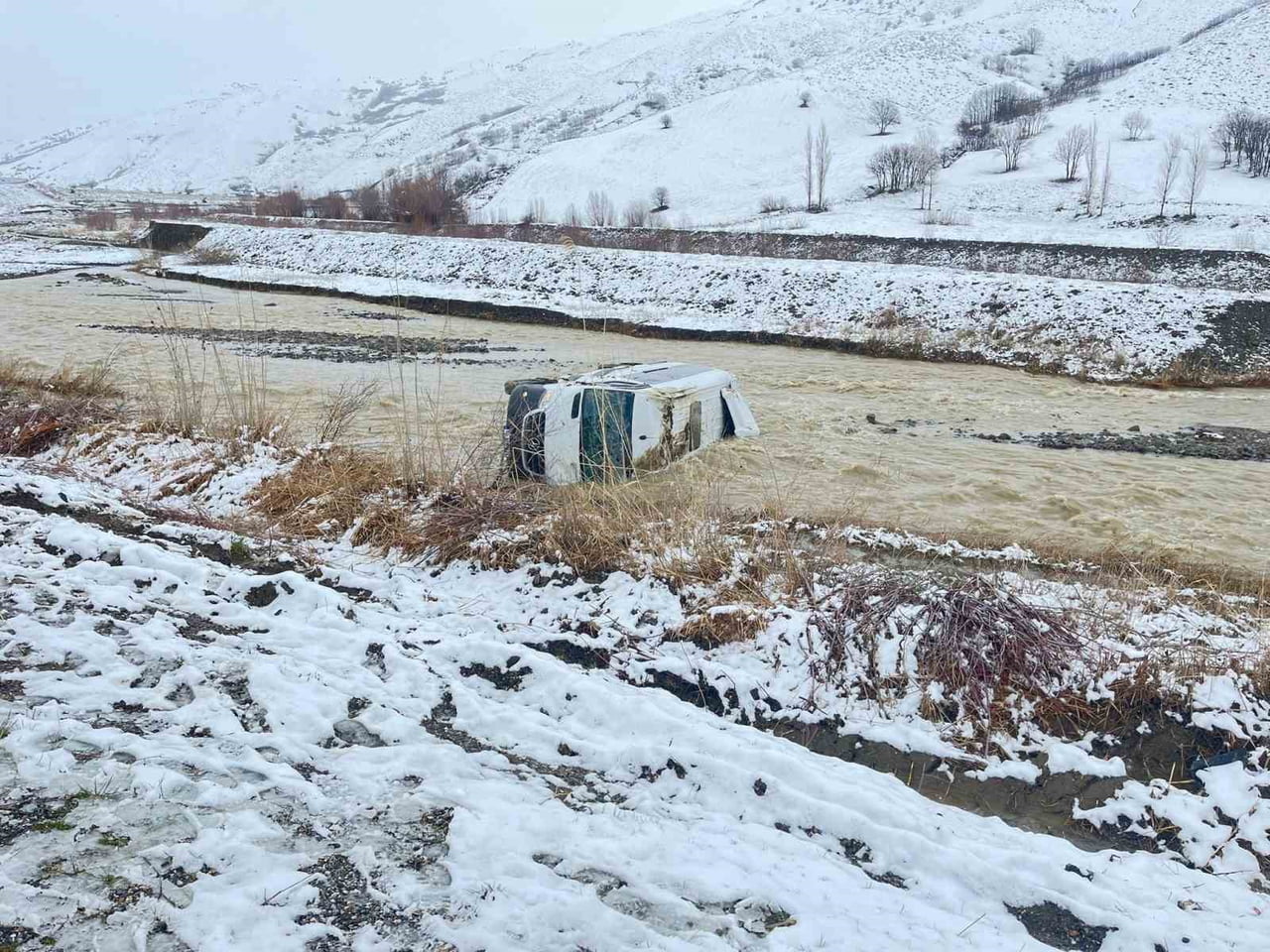 MUŞ’UN KORKUT İLÇESİNDE KAR YAĞIŞI NEDENİYLE KAYGANLAŞAN YOLDA KONTROLDEN ÇIKAN MİNİBÜSÜN DEREYE...