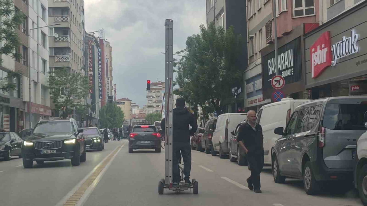 ESKİŞEHİR'DE BİR VATANDAŞ KENDİ BOYUNDAN UZUN MERDİVENİ TRAFİK AKIŞININ DEVAM ETTİĞİ BİR CADDE DE...