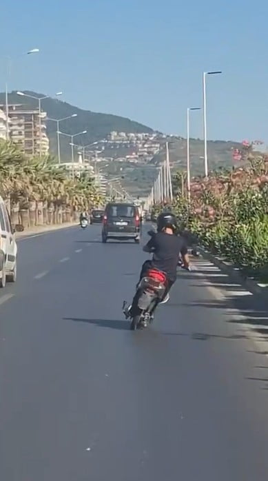 ANTALYA'NIN ALANYA İLÇESİNDE HAREKET HALİNDEKİ ELEKTRİKLİ MOTOSİKLETİN ÜZERİNE AYAĞA KALKARAK...
