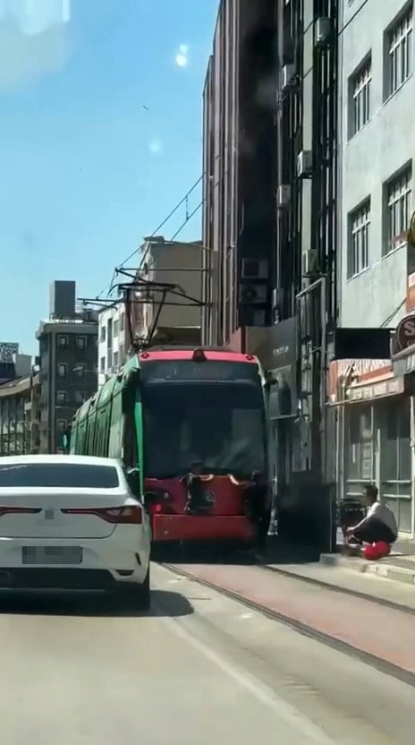 BURSA'DA SEYİR HALİNDEKİ TRAMVAYIN ARKASINA TUTUNARAK YOLCULUK YAPAN İKİ ÇOCUK, CEP TELEFONU...