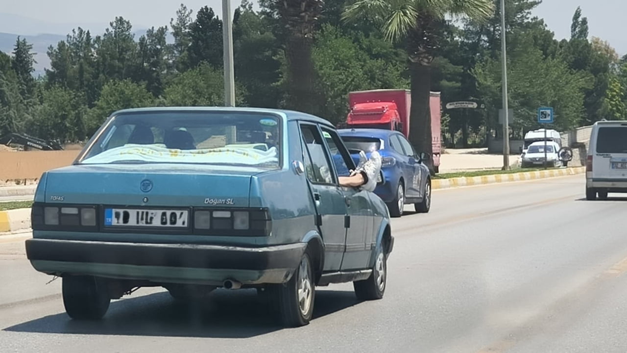 DENİZLİ ANKARA BULVARI’NDA BİR TOFAŞ MARKA OTOMOBİLDE YOLCUNUN AYAKLARINI CAMDAN ÇIKARMASI...